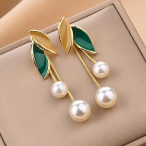 A pair of green and gold leaf earrings with two pearls dangling from each.